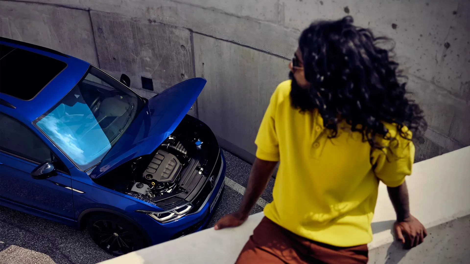 An Autohaus Namibia technician and customer looking under a Volkswagen